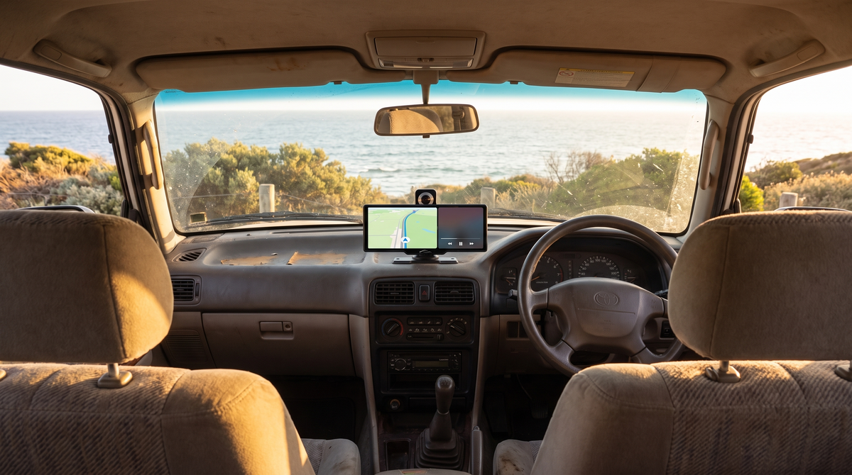 Portable CarPlay screen on an SUV dashboard on a coastal road trip